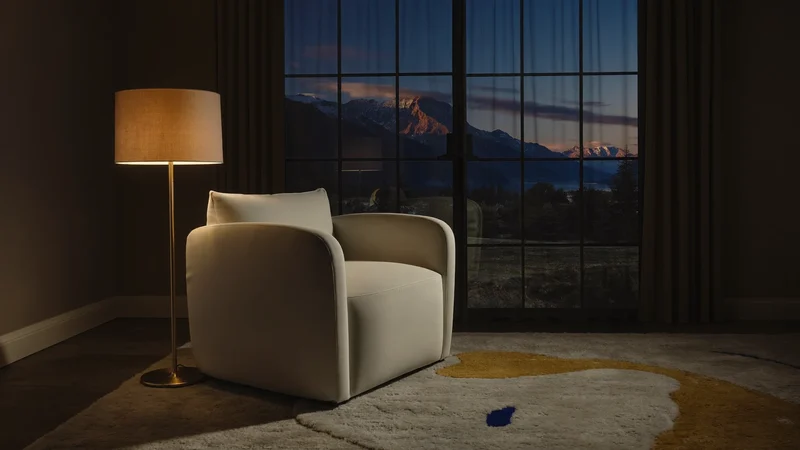 Gestaltete Zimmerecke mit Sessel, Stehlampe und Teppich im warmen Abendlicht